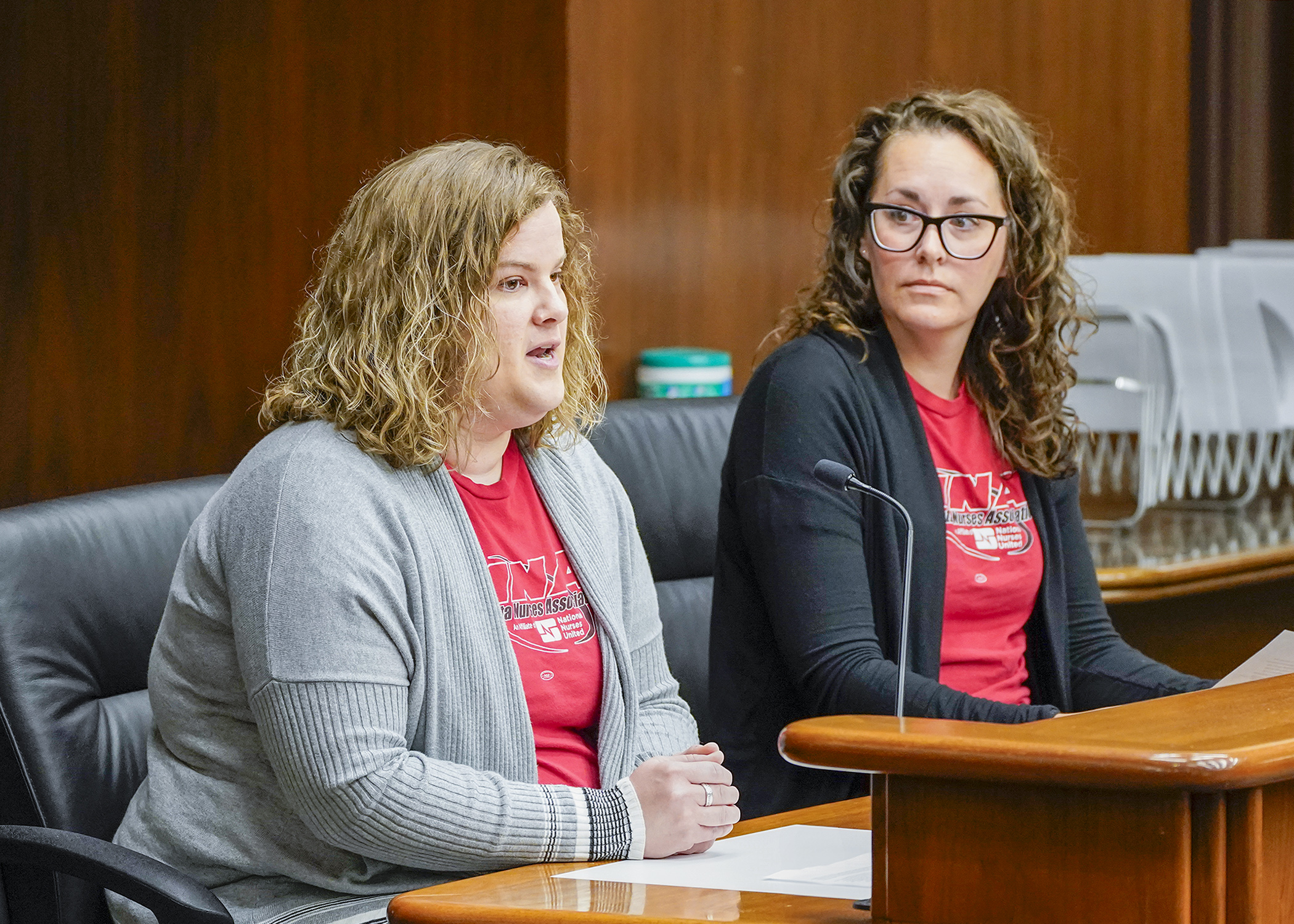 Nurses Mariah Tunkara and Janell Johnson Thiele testify before the House Health Finance and Policy Committee May 7 during an informational hearing on a bill that would modify the governing provisions of Hennepin Healthcare System. (Photo by Andrew VonBank)